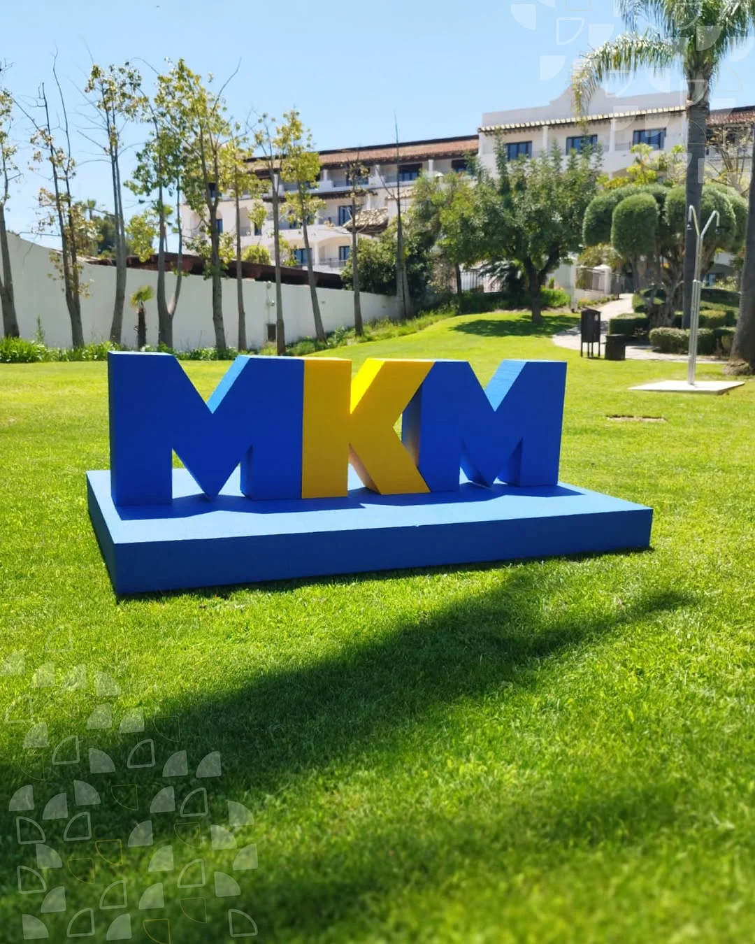 Letras corporativas Marbella en azul y amarillo de un metro de alto montadas sobre el césped del resort