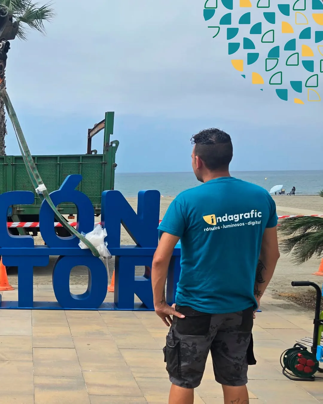 Operario con camiseta de Indagrafic durante la rotulación Rincón de la Victoria en el paseo marítimo