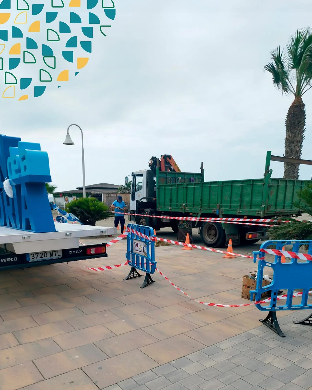 Camión grúa balizado durante la instalación de la rotulación Rincón de la Victoria en el paseo marítimo