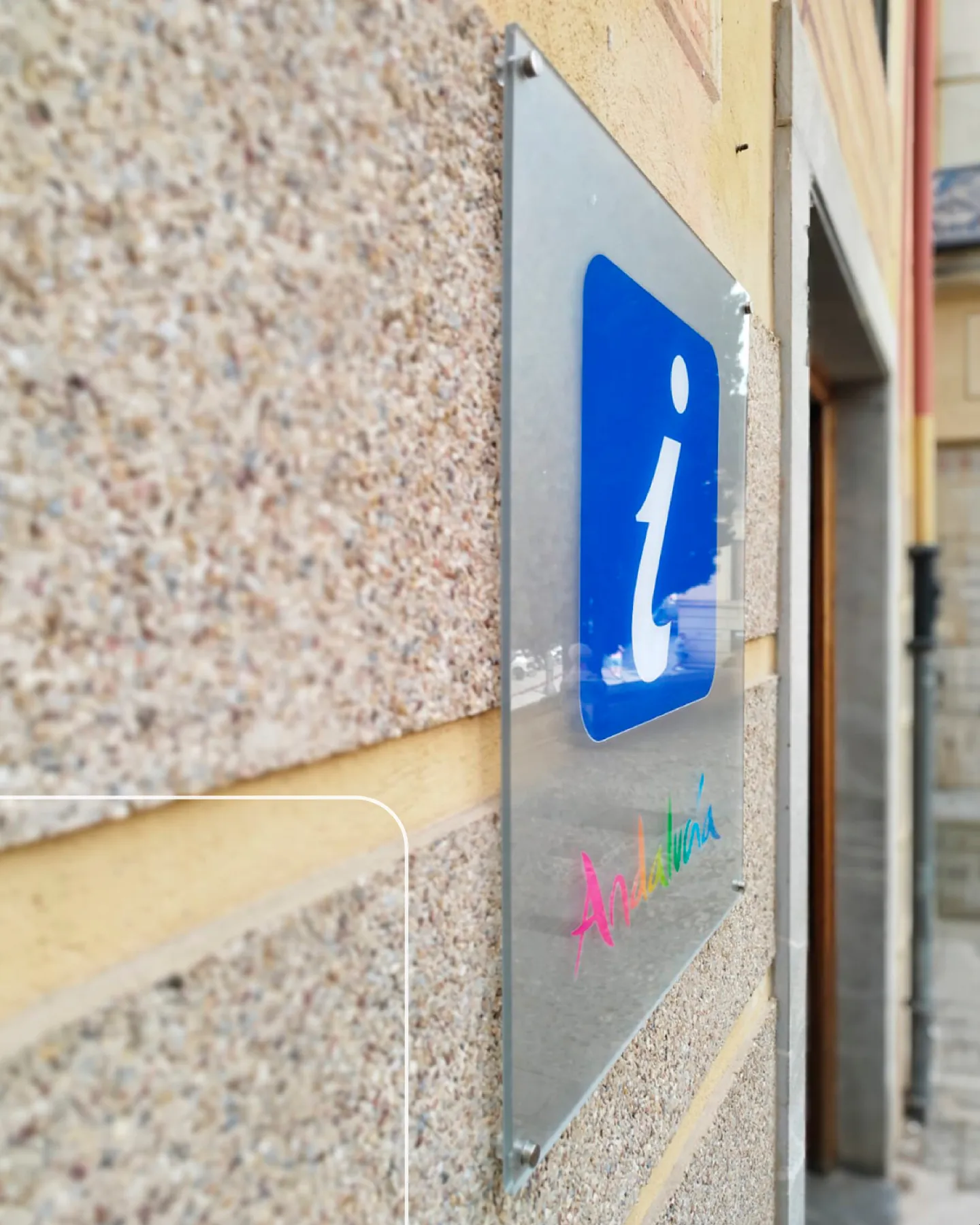 Placa de metacrilato con el pictograma de información en la rotulación de oficinas de turismo de Andalucía