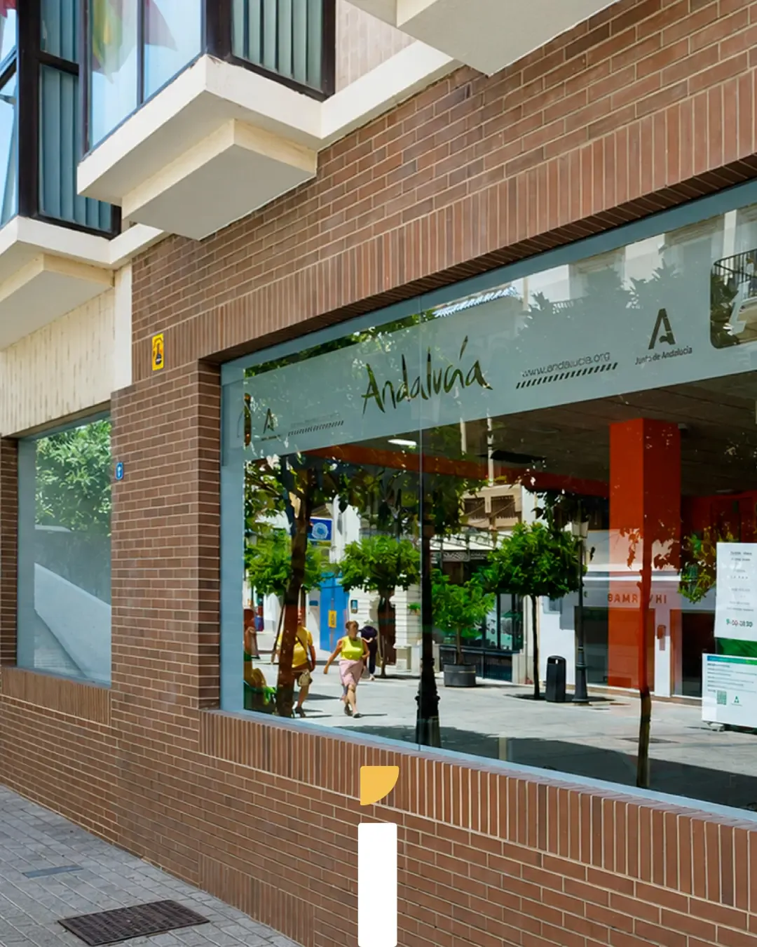 Rotulación en Andalucía: escaparate de oficina de turismo con vinilo Andalucía en calle peatonal