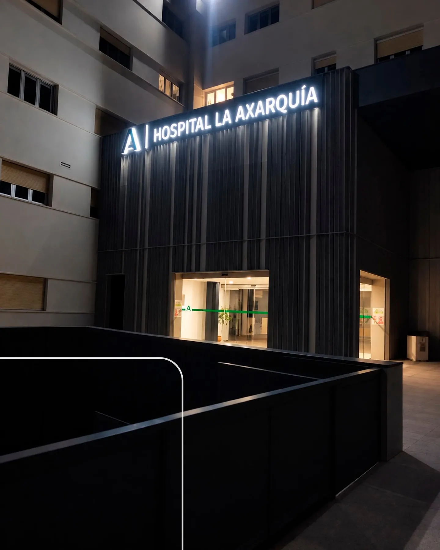 Rotulación del Hospital La Axarquía en su fachada iluminada de noche