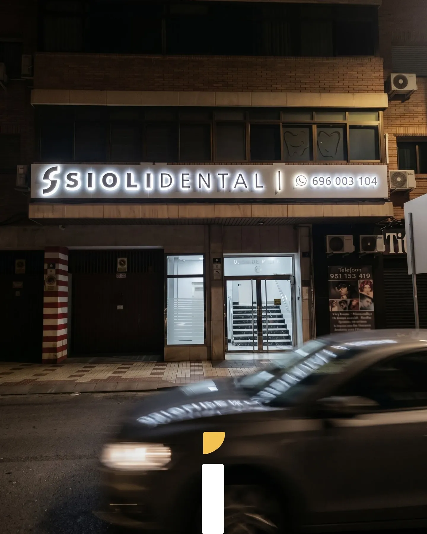 Rótulo de Siolidental iluminado de noche con LED blanco cálido sobre la fachada